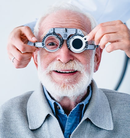 An older man during an eye exam with special ophthalmic glasses on his face