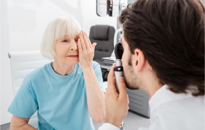 An older woman receiving an eye exam to detect cataracts.